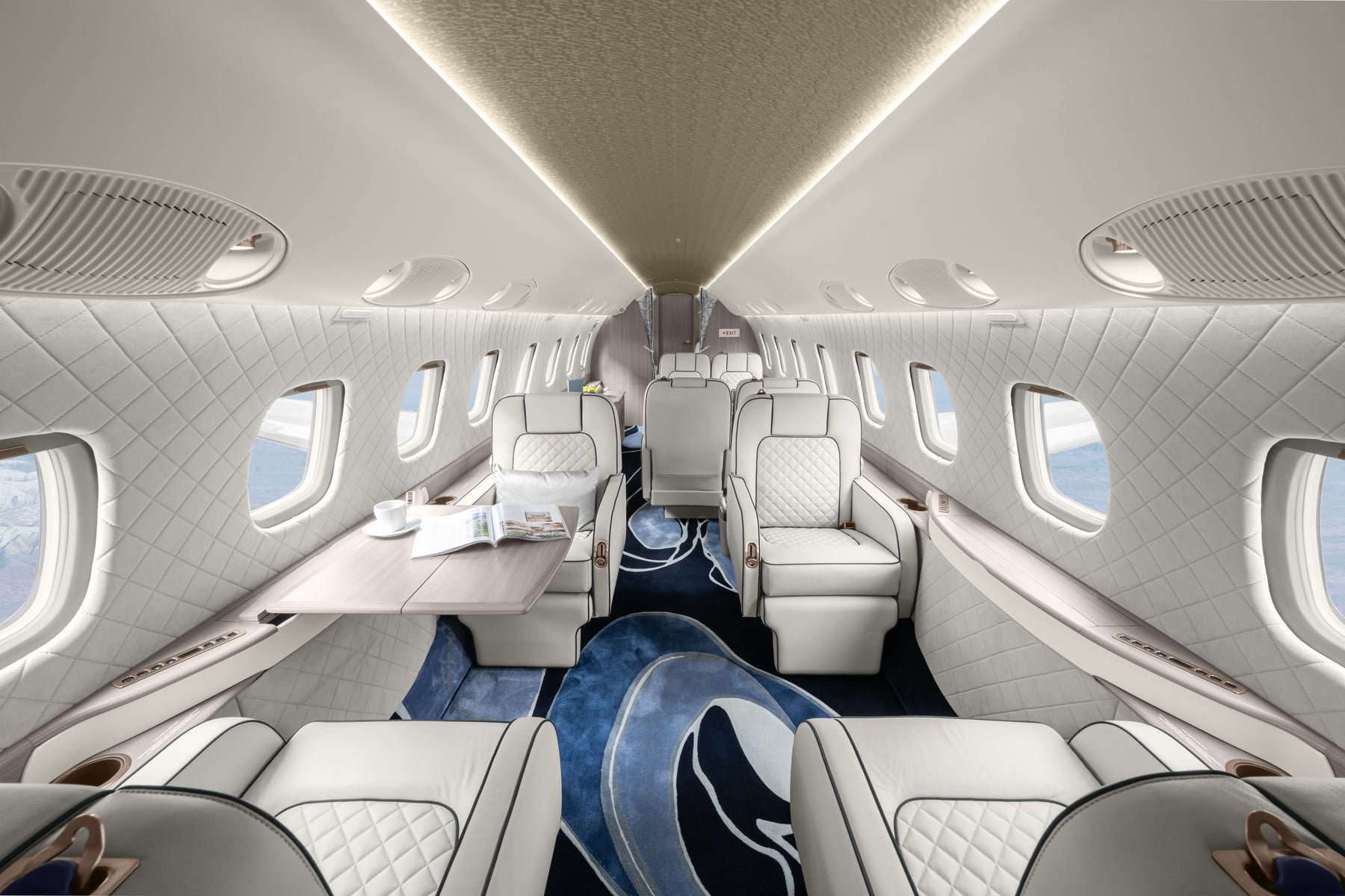 Luxury private jet cabin interior with cream leather seats and polished wood trim